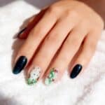 Manicure gel con nail art natalizia su base lattiginosa e unghie blu scuro