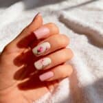 Manicure gel rosa chiaro con nail art floreale delicata su base lattiginosa