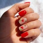 Unghie gel rosse con decorazione floreale delicata