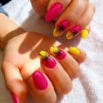 Manicure gel con nail art tropicale fucsia e gialla con palme stilizzate
